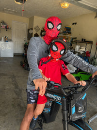 Family posing with a blue Buzymoto electric dirt bike and a Spider-Man character