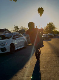 Terrawulf M7 electric dirt bike riding along a street at sunset, featured by Dirt Bike Mall